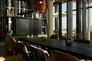 a dining room with a large black table and chairs at The Cloud One Düsseldorf-KöBogen in Düsseldorf