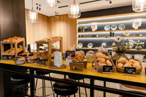 a bakery with bread and pastries on a table at Motel One Madrid-Plaza de España in Madrid