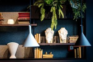 a book shelf with books and a lamp on it at Motel One Karlsruhe in Karlsruhe