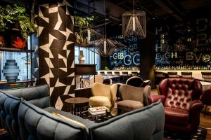 a bar with couches and chairs in a room at Motel One Karlsruhe in Karlsruhe +40 photos