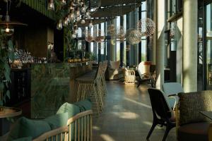 a restaurant with chairs and a bar with chandeliers at The Cloud One Düsseldorf-KöBogen in Düsseldorf