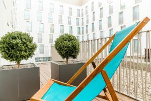 a blue chair on a balcony with trees at Motel One Köln-Neumarkt in Cologne