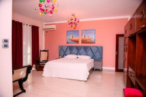 a bedroom with a white bed and pink walls at Sella Villa-Transit Airport in Seeduwa