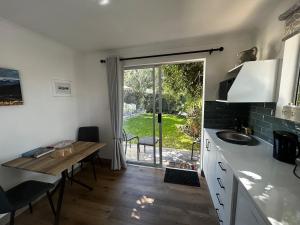 a kitchen with a table and a sink and a window at Dove Cottage in Oakdale +8 photos