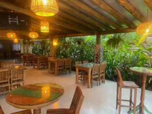 a restaurant with tables and chairs and lights at Velejador Hotel, a 5 minutos do Centro Histórico, com estacionamento! in Paraty