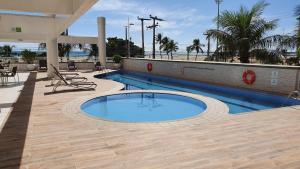 a swimming pool on a patio next to a beach at Holiday Inn Fortaleza by IHG in Fortaleza