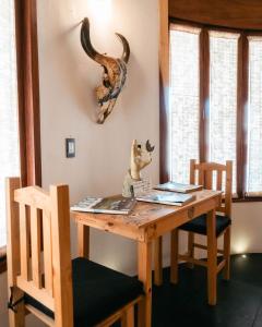 a wooden table with two chairs and a table with horns on the wall at Sicaru Mazunte in Mazunte