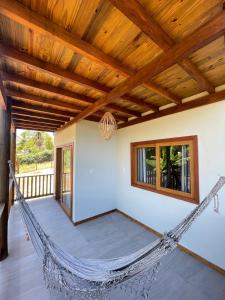 a hammock in a room with a wooden ceiling at Vila Baião - Casa Luiz Gonzaga in Itacaré