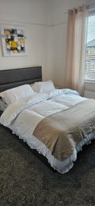 a large bed in a bedroom with a window at Sandringham House in Stockton-on-Tees