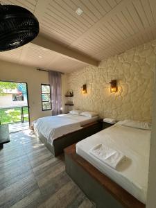a bedroom with two beds and a stone wall at New Western Llanos Stay in Acacías