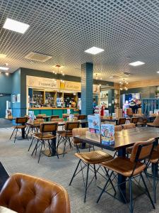 a cafeteria with tables and chairs in a store at Ocean Pearl Home in Heysham