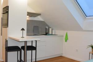 an attic kitchen with a counter and stools at Modernes Dachgeschoss in Augsburg