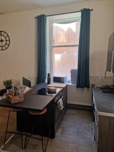 a kitchen with a desk and a large window at Baile Apartment Central Inverness in Inverness