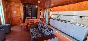 a kitchen with a couch and a sink and a table at Cabañas Biancomoro Olmue in Olmué