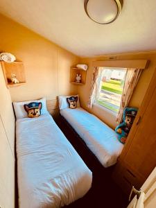 two beds in a small room with a window at Ocean Pearl Home in Heysham +18 photos