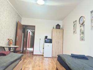 a room with two beds and a refrigerator and a table at Penzion Bilina in Teplice
