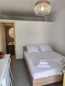 a bedroom with a bed with white sheets and a light at Ventalia in Kimolos
