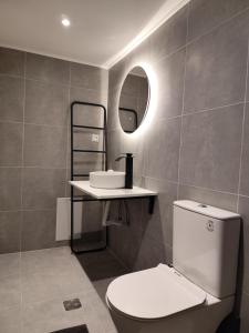 a bathroom with a toilet and a sink and a mirror at Ventalia in Kimolos