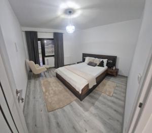 a bedroom with a bed and a table and a chair at La Olivia în Pădure in Tihuţa