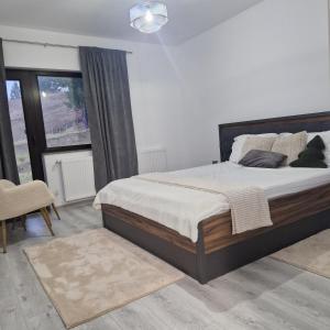 a bedroom with a bed and a large window at La Olivia în Pădure in Tihuţa