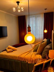 a bedroom with a bed with a light hanging over it at GZP Residence Lugoj 14 in Lugoj