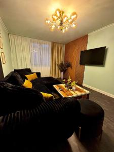 a living room with a black couch and a table at GZP Residence Lugoj 14 in Lugoj +3 photos