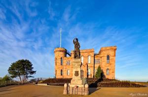 a building with a statue on top of it at Baile Apartment Central Inverness in Inverness