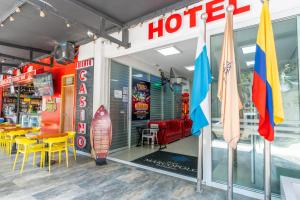 a store front with tables and chairs and flags at Hotel Marco Polo Rodadero in Santa Marta