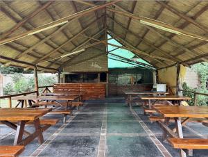 a group of wooden tables and benches in a pavilion at Cabañas La Cautiva in Tanti