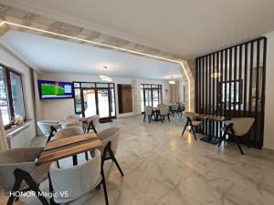 a dining room with tables and chairs and windows at MOFT Borsa in Statjunea Borsa
