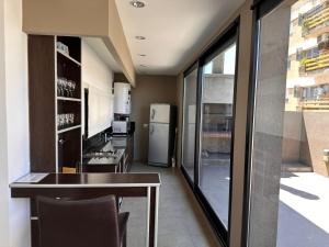a kitchen with a dining table and a large window at Apart Maral Zárate in Zárate