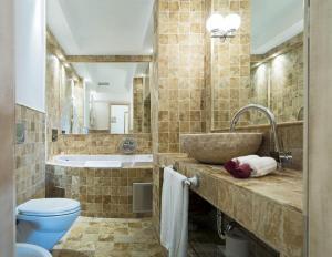 a bathroom with a sink and a toilet and a tub at Hotel Azimut in Sveti Stefan