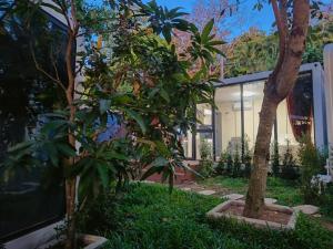 a house with trees in front of a building at NeOtel Apartments in Ban Saiyuan (1)
