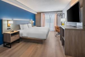 a hotel room with a bed and a flat screen tv at Comfort Inn Belleville in Belleville