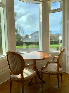 a table and two chairs in front of a window at The Manor House in Peel