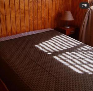a bedroom with a bed with the sun shining on it at Cabañas Biancomoro Olmue in Olmué