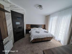 a bedroom with a bed and a large window at MOFT Borsa in Statjunea Borsa