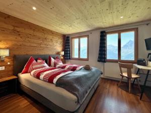 a bedroom with a bed with red pillows at Berggasthaus Eggberge - Boutique Mountain Hotel - Access via Cablecar in Altdorf