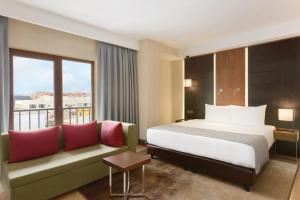 um quarto de hotel com uma cama e um sofá em Ramada by Wyndham Istanbul Florya em Istambul