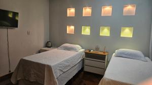 two beds in a hospital room with lights on the wall at Mendes Residence in Belém +130 photos