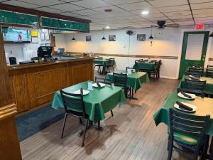 a dining room with green tables and chairs at Jacksonville Inn in Jacksonville