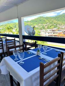 a table with wine glasses on a blue table cloth at Sea Blue Suites in Angra dos Reis