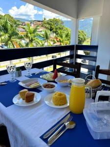 a blue table with plates of food on a balcony at Sea Blue Suites in Angra dos Reis