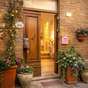 a front door of a brick house with potted plants at Il Nido del Vicolo in Città della Pieve