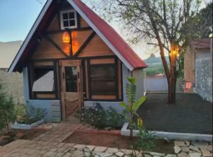 a tiny house with a red roof at Chalé amora Analândia in Analândia