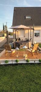 a deck with two chairs and a large umbrella at Loft 212 in Chitenay