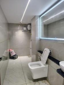 a bathroom with a white toilet and a sink at Hotel Red Rose in Vadodara +6 photos
