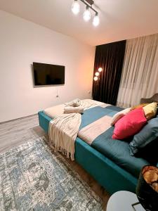 a bedroom with a bed and a flat screen tv at GZP Residence Lugoj 19 in Lugoj