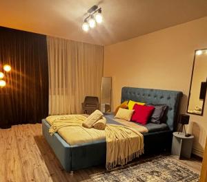 a bedroom with a blue bed with colorful pillows at GZP Residence Lugoj 19 in Lugoj