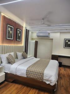 a bedroom with a large bed and a desk at Hotel Red Rose in Vadodara